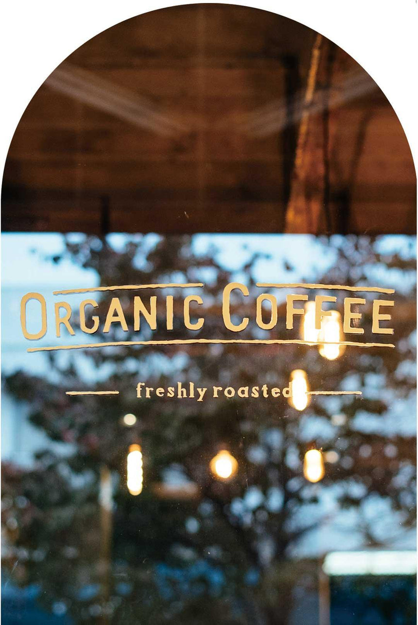 おしゃれのカフェの窓に描かれた文字：オーガニックコーヒー Organic coffee freshly roasted